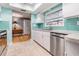 Updated kitchen with teal backsplash, stainless steel appliances, and white cabinets at 2240 Colonial Dr, Dunedin, FL 34698