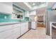 Bright kitchen featuring stainless steel appliances and teal tile backsplash at 2240 Colonial Dr, Dunedin, FL 34698