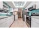 Modern kitchen with stainless steel appliances and teal tile backsplash at 2240 Colonial Dr, Dunedin, FL 34698