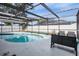 Kidney shaped pool with screened enclosure at 2240 Colonial Dr, Dunedin, FL 34698