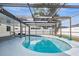Kidney shaped pool with screened enclosure at 2240 Colonial Dr, Dunedin, FL 34698