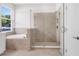 Bright bathroom featuring a soaking tub, glass shower with neutral tile surround, and a crisp, clean aesthetic at 2729 36Th N Ave, St Petersburg, FL 33713
