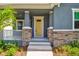 Close-up view of a home's welcoming front porch with stone accents and a vibrant yellow door at 2729 36Th N Ave, St Petersburg, FL 33713
