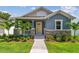Charming blue single-story home with a welcoming yellow front door, stone accents, and a beautifully landscaped yard at 2729 36Th N Ave, St Petersburg, FL 33713