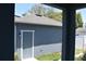Garage with a blue exterior, well-manicured lawn, white trim, and a single access door at 2729 36Th N Ave, St Petersburg, FL 33713