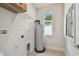 Utility room with water heater, shelving, and connections at 2729 36Th N Ave, St Petersburg, FL 33713