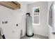 Neat utility room featuring a hot water tank, storage, and a bright window at 2729 36Th N Ave, St Petersburg, FL 33713