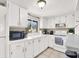 White kitchen with microwave, stove and ample cabinet space at 3869 S Lake Dr # 146, Tampa, FL 33614