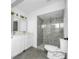 Bathroom with double vanity, gray tile shower, and toilet at 4901 W Bartlett Dr, Tampa, FL 33603