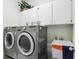 Laundry room with washer, dryer, cabinets, and utility sink at 8719 Ashworth Dr, Tampa, FL 33647