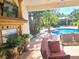 Relaxing patio with pool view and outdoor fireplace at 10628 Pontofino Cir, Trinity, FL 34655