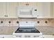 Electric cooktop and microwave in white kitchen at 1510 Ingram Dr, Sun City Center, FL 33573