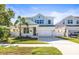 Two-story light blue house with a white garage door and landscaping at 1820 47Th N Ave, St Petersburg, FL 33714
