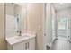 A view of the bathroom vanity and mirror with an adjacent hallway and doorway at 2735 36Th N Ave, St Petersburg, FL 33713
