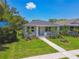 Charming single-story home with a well-manicured lawn, sidewalk, and small, vibrant palm trees at 2735 36Th N Ave, St Petersburg, FL 33713