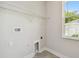 A laundry room featuring tile flooring, white walls and trim, and a window at 2735 36Th N Ave, St Petersburg, FL 33713
