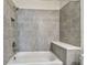 This is a gray tiled shower and tub combo with a shower head, faucet, and a small seat at 2735 36Th N Ave, St Petersburg, FL 33713