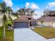 One story house with a gray garage door and a nicely landscaped front yard at 31330 Spoonflower Way, Brooksville, FL 34602