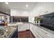 White kitchen with granite countertops, farm sink, and dark mosaic backsplash at 4 Belleview Blvd # 402, Belleair, FL 33756