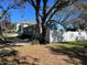 Blue house exterior with a white fence and mature trees at 401 81St Ne Ave, St Petersburg, FL 33702