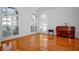 Sunlit living room featuring hardwood floors and large arched windows with plantation shutters at 4404 W Azeele St, Tampa, FL 33609