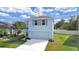 Two-story house with light blue exterior, two-car garage, and small yard at 5018 Bella Armonia Cir, Wimauma, FL 33598