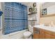 Clean bathroom with shower/tub, wood vanity, and patterned curtain at 8722 Mallard Reserve Dr # 204, Tampa, FL 33614
