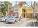 Condo building with brick and yellow siding, stairs, and parking at 8722 Mallard Reserve Dr # 204, Tampa, FL 33614