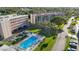 Aerial view of condo building with pool and surrounding landscape at 9433 Harbor Greens Way # 403, Seminole, FL 33776