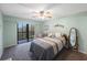 Bright bedroom with a queen-size bed and sliding glass doors leading to a balcony at 9433 Harbor Greens Way # 403, Seminole, FL 33776