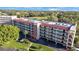 A condo building with a red roof and balconies surrounded by trees and a golf course, creating a serene environment at 9433 Harbor Greens Way # 403, Seminole, FL 33776
