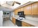 Kitchen with wood cabinets, white appliances, and a breakfast bar at 9433 Harbor Greens Way # 403, Seminole, FL 33776