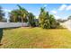 Large backyard with lush tropical landscaping and a white vinyl fence at 12610 Saulston Pl, Hudson, FL 34669
