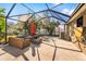 Spacious screened patio with comfortable seating and a red umbrella at 12610 Saulston Pl, Hudson, FL 34669