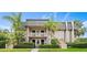 Two-story condo building with gray tile roofs, lush landscaping, and a paved walkway at 1403 Cordova Grn, Seminole, FL 33777
