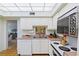 White kitchen cabinets and appliances, with a view into the dining area at 1403 Cordova Grn, Seminole, FL 33777
