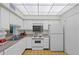 Clean and bright kitchen with white cabinets and a built-in microwave at 1403 Cordova Grn, Seminole, FL 33777