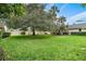 Expansive grassy area with mature trees and lush greenery at 1403 Cordova Grn, Seminole, FL 33777