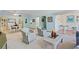 Bright living room with comfy armchairs, a coffee table, and access to a sunroom at 1403 Cordova Grn, Seminole, FL 33777