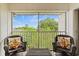 Relaxing screened balcony with wicker furniture and leafy views at 1403 Cordova Grn, Seminole, FL 33777