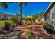 Private backyard patio with terracotta tile, seating area, and colorful plants at 2473 Bentley Dr, Palm Harbor, FL 34684