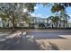 Two-story light green house with a white door, landscaping, and a metal roof on a sunny day at 322 Ibisview Ln, Apollo Beach, FL 33572
