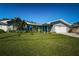 Ranch-style home with gray exterior, white garage door, and green lawn at 3875 Mckay Creek Dr, Largo, FL 33770