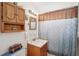 Clean bathroom with a shower/tub combo and wood cabinet at 401 Davison Ne Ave, St Petersburg, FL 33703