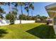 Lush backyard featuring a well-maintained lawn, bordered by a white vinyl fence and mature trees for privacy at 4510 Helena Ne St, St Petersburg, FL 33703