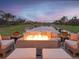 Relaxing patio with fire pit overlooking a lake at 5011 Sandy Brook Cir, Wimauma, FL 33598