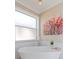 Luxurious bathroom with a freestanding soaking tub and a large-scale floral print at 5011 Sandy Brook Cir, Wimauma, FL 33598