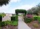 Entrance to community garden with arbor, gate, and lush landscaping at 5011 Sandy Brook Cir, Wimauma, FL 33598