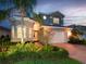 Charming two-story home boasts a well-manicured lawn and a paver driveway leading to a two-car garage at 5011 Sandy Brook Cir, Wimauma, FL 33598
