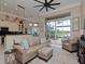 Gathering room features comfortable seating, access to the kitchen and backyard at 5011 Sandy Brook Cir, Wimauma, FL 33598